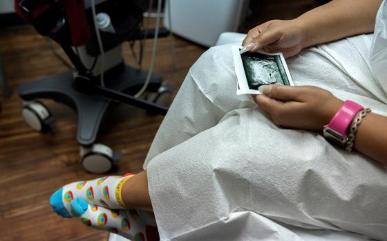 A woman in Houston looks at a picture of her ultrasound at Houston Women's Reproductive Services Oct. 1, 2021. (CNS/Reuters/Evelyn Hockstein)