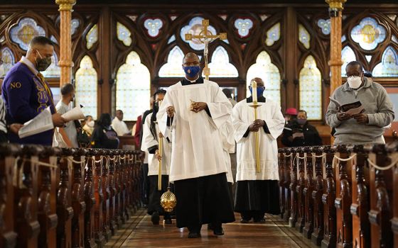 Toby Offiah, a seminarian of the Diocese of Brooklyn, New York, leads the opening procession during a Mass marking Black Catholic History Month Nov. 21, 2021, at Our Lady of Victory Church in the Bedford-Stuyvesant section of Brooklyn. (CNS)