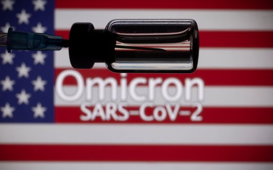 A vial, syringe and U.S. flag are seen in this illustration about a new variant of the coronavirus the medical world has labeled "Omicron." (CNS photo/Dado Ruvic, Reuters)