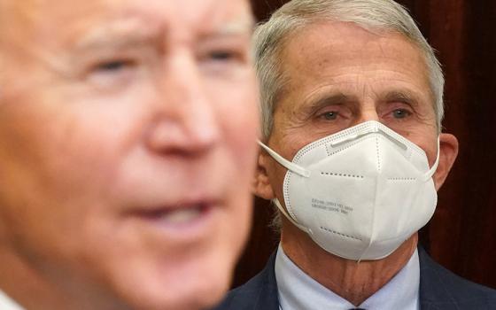 At the White House in Washington Nov. 29, Dr. Anthony Fauci, director of the National Institute of Allergy and Infectious Diseases, listens to President Joe Biden deliver an update on the omicron coronavirus variant. (CNS/Reuters/Kevin Lamarque)