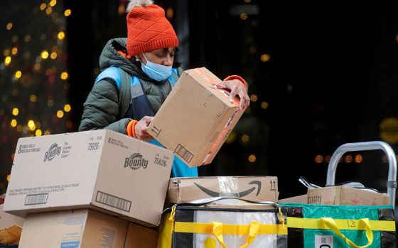 An Amazon delivery worker in New York City stacks boxes on Cyber Monday Nov. 29, 2021. (CNS/Reuters/Brendan McDermid)