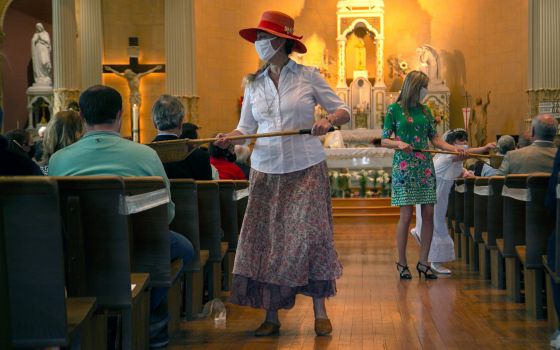 Parishioners at St. James Catholic Church in Louisville, Ky., use collection baskets April 4, 2021, amid the coronavirus pandemic. (CNS/Reuters/Amira Karaoud)
