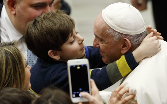A boy embraces Pope Francis during his general audience in the Paul VI hall at the Vatican Dec. 15, 2021. (CNS photo/Paul Haring)