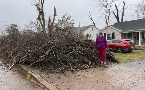 Anita "Annie" Adams of Bowling Green, Ky., stands next to the tornado debris pile in front of her house Dec. 18, 2021. (CNS photo/courtesy Jonathan Oglesby) 