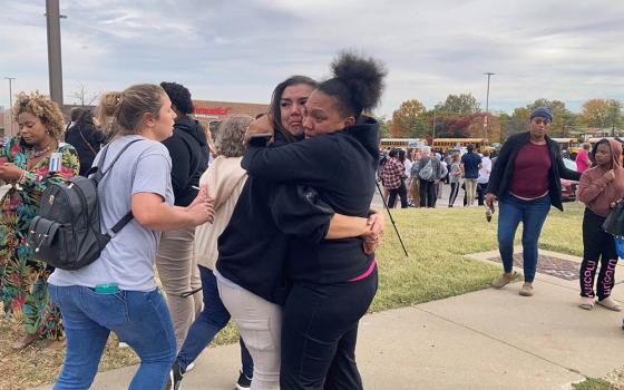 People in St. Louis embrace following a shooting at a high school Oct. 24. (CNS/NPR Midwest Newsroom via Reuters/Holly Edgell)