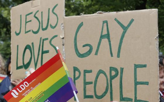 People hold a rainbow flag and signs during a 2014 gay pride parade in Oslo, Norway.