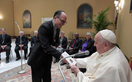 Man hands report to Pope Francis