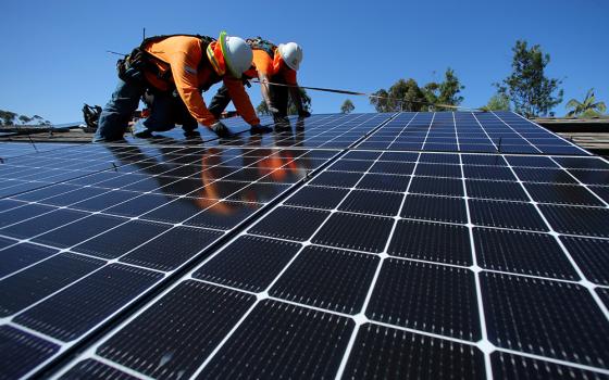 Solar installers are seen on a residential home Oct. 14, 2016, in Scripps Ranch, California. (CNS/Reuters/Mike Blake)