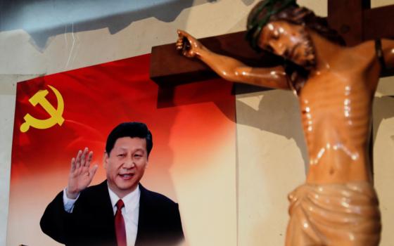 A poster of Chinese President Xi Jinping hangs next to a crucifix on the wall of the house of a Tibetan Catholic
