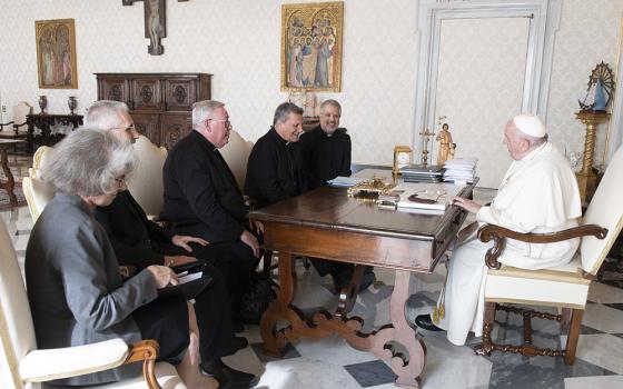 Pope Francis meets with leaders of the Synod of Bishops' general secretariat in the library of the Apostolic Palace at the Vatican Oct. 14. Pictured with the pontiff are Xavière Missionary Sr. Nathalie Becquart, undersecretary; Bishop Luis Marín de San Martín, undersecretary; Cardinal Jean-Claude Hollerich of Luxembourg, relator general; Cardinal Mario Grech, secretary-general; and Jesuit Father Giacomo Costa, consultant. (CNS/Vatican Media)