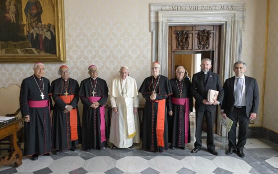 Pope Francis poses for a photo with leaders of the Latin American bishops' council, or CELAM, in the library of the Apostolic Palace at the Vatican Oct. 31, 2022.