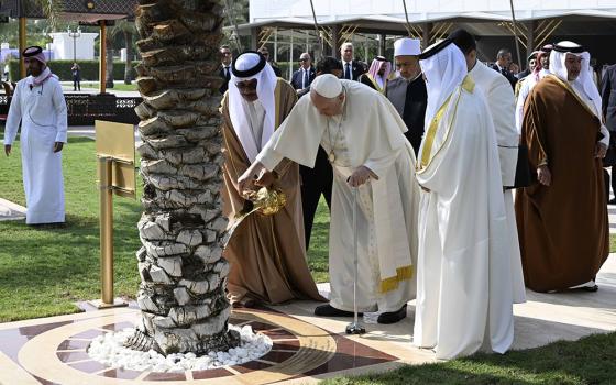 Pope Francis waters a palm tree before addressing the Bahrain Forum for Dialogue: East and West for Human Coexistence Nov. 4 in Awali, Bahrain. (CNS/Vatican Media)