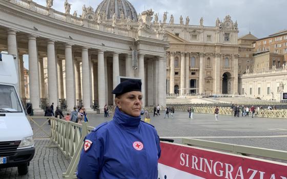 A volunteer with the Italian Red Cross stands in St. Peter's Square Nov. 10, 2022, ready to welcome anyone who wants a free medical exam or blood test being offered by volunteer physicians, nurses and medical students as part of the Vatican celebration of the World Day of the Poor. 