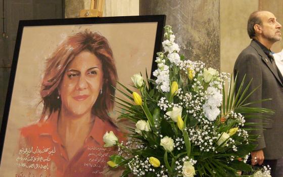 A portrait of Shireen Abu Akleh stands alongside flowers on Oct. 26 at the entrance of the Basilica of Santa Maria in Cosmedin, historically considered the home church for Catholics practicing in the Greek Melkite rite in Rome. (Rome Reports/Justin McLellan)