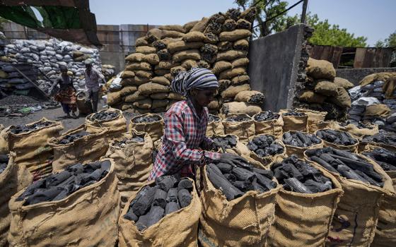 A woman works at a coal depot May 2 in Ahmedabad, India. (AP photo/Ajit Solanki, File)