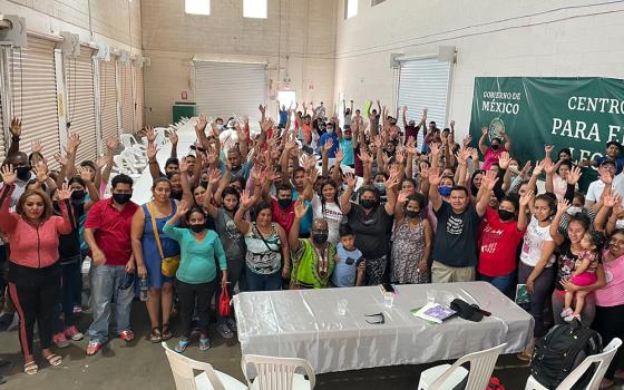 Fr. Stan Chu Ilo, center, wearing green, poses with people at a holding center for migrants in Ciudad Juarez, Mexico. Ilo and others interviewed the people at the center for the Vatican's "Doing Theology from the Existential Peripheries" project. (Courtesy of Stan Chu Ilo)