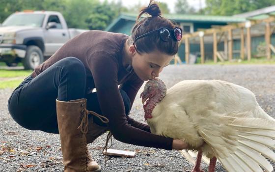 Catskill Animal Sanctuary communications manager Veronica Finnegan shares a tender moment with Michael the turkey, rescued from the street outside a local turkey farm just before Thanksgiving. (Courtesy of Catskill Animal Sanctuary)