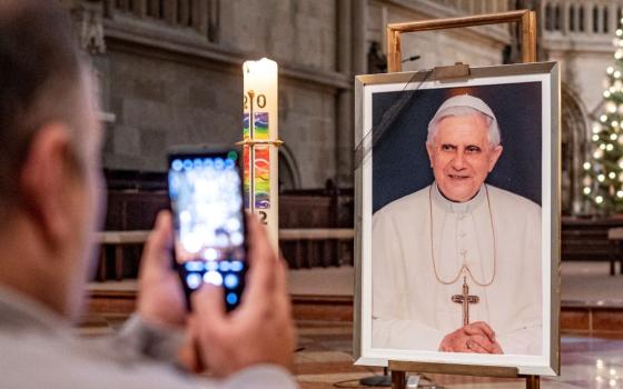 Person takes photo of photo of Pope Benedict