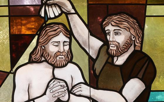 The baptism of Christ by John the Baptist is depicted in a stained-glass window at St. Anthony's Church July 15, 2021, in North Beach, Maryland. (CNS/Bob Roller)