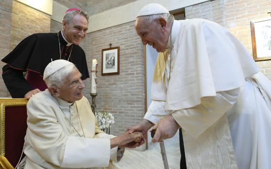 Pope Francis greets retired Pope Benedict XVI at the Mater Ecclesiae monastery after a consistory for the creation of 20 new cardinals in St. Peter's Basilica at the Vatican Aug. 27, 2022. Looking on is Archbishop Georg Gänswein, the retired pope's private secretary. (CNS photo/Vatican Media)