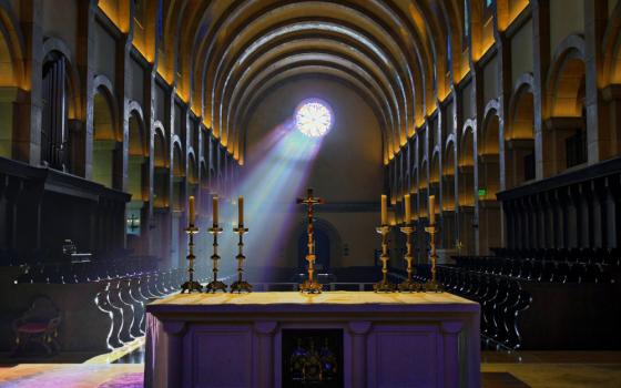 Light streams through a window into a chapel with an altar
