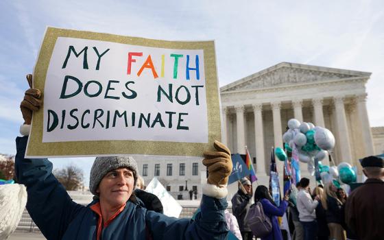 A protester displays a sign during a demonstration outside the U.S. Supreme Court Dec. 5 in Washington, as justices hear arguments in the case of a Colorado website designer who refuses to create websites for same-sex marriages due to her Christian beliefs about traditional marriage. (CNS/Reuters/Kevin Lamarque)