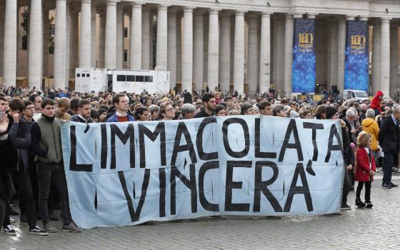 A group of people in St. Peter's Square holds banner that reads "L'Immacolata Vincera"