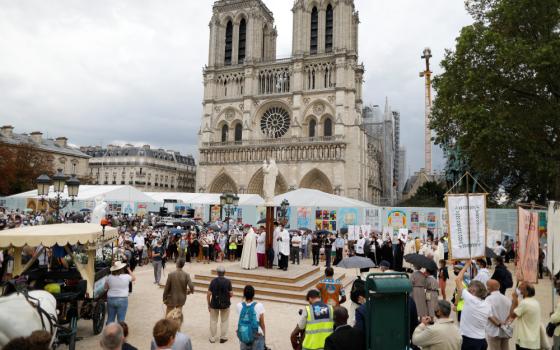 People gather around priests outside Notre Dame Cathedral