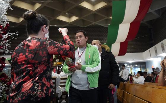Worshippers receive Communion during a Spanish-language Mass celebrated on the eve of the feast of Our Lady of Guadalupe at Our Lady of Mount Carmel Church in Staten Island, New York, Dec. 11. Our Lady of Mount Carmel-St. Benedicta-St. Mary of the Assumption Parish ministers to a large population of immigrants from Mexico. (CNS/Gregory A. Shemitz)