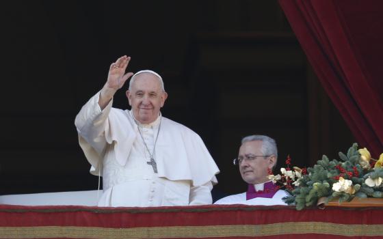 Pope Francis greets the crowd as he arrives to deliver his Christmas message and his blessing "urbi et orbi" (to the city and the world) from the central balcony of St. Peter's Basilica at the Vatican Dec. 25, 2022.