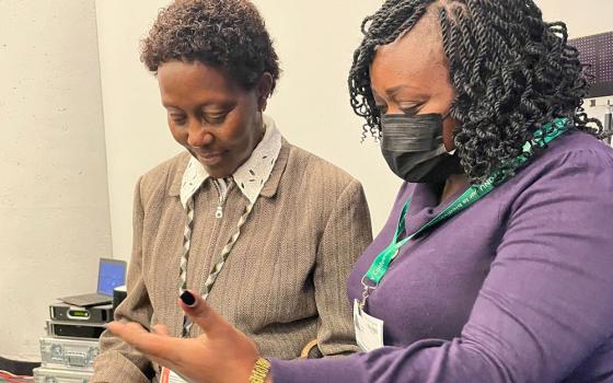 Caroline Kiiru (right), biodiversity and climate change campaign manager for Laudato Si' Movement, presents a petition signed by 231,000 Catholics to Elizabeth Mrema, executive secretary of the U.N. Convention on Biological Diversity. (Courtesy of Laudato Si' Movement)