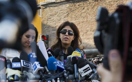 Italian communications expert Francesca Chaouqui talks to journalists July 7, 2016, after a Vatican court convicted her and a Vatican monsignor for having conspired to pass documents to two Italian journalist. A Vatican trial into a money-losing investment has been jolted by revelations that a key prosecution witness was apparently manipulated into changing his story and cooperating with prosecutors. (AP Photo/Domenico Stinellis, File)