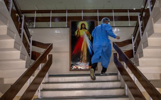 Rohan Aggarwal, 26, a resident doctor treating patients suffering from COVID-19, rushes to an emergency call at a ward for COVID-19 patients, during his 27-hour shift at Holy Family Hospital in New Delhi in this May 1, 2021, file photo. (CNS photo/Danish 