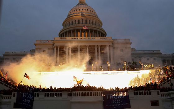 An explosion caused by a police munition is seen while supporters of then-President Donald Trump gather in front of the U.S. Capitol Building in Washington on Jan. 6, 2021. (CNS/Reuters/Leah Millis)