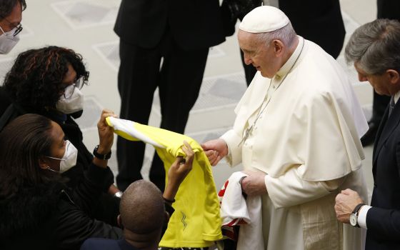 Pope Francis accepts a Vatican Athletic team jersey from Wendie Renard, a French professional soccer player for the Olympique Lyonnais Féminin club, during his general audience in the Paul VI hall at the Vatican Jan. 12, 2022. (CNS photo/Paul Haring)