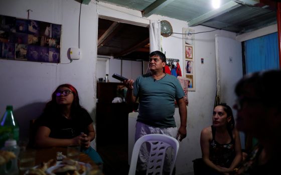 Gustavo Delgado, 52, who lost his job during the COVID-19 outbreak, celebrates his daughter's 12th birthday at home in Buenos Aires, Argentina, in this Nov. 17, 2020. (CNS photo/Agustin Marcarian, Reuters)