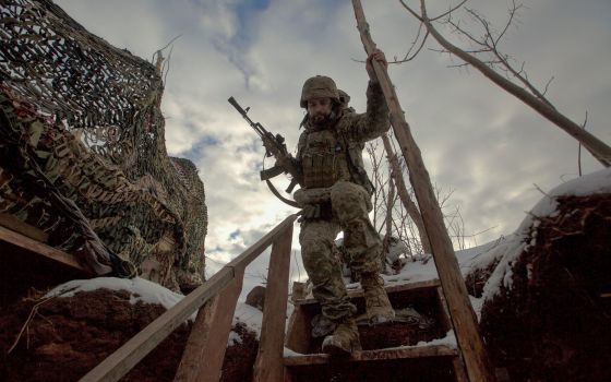 A service member with the Ukrainian armed forces walks past combat positions near a line of separation from Russian-backed rebels near Horlivka in the Donetsk region of Ukraine Jan. 22, 2022. (CNS photo/Anna Kudriavtseva, Reuters)