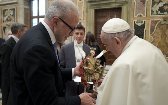 Pope Francis accepts a gift during an audience with a delegation from the Agenzia delle Entrate, Italy's governmental tax agency, at the Vatican Jan. 31, 2022.(CNS photo/Vatican Media)