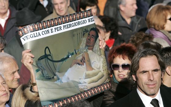 Mourners hold a picture of Piergiorgio Welby during his funeral in Rome in this Dec. 24, 2006. (CNS photo/Max Rossi)