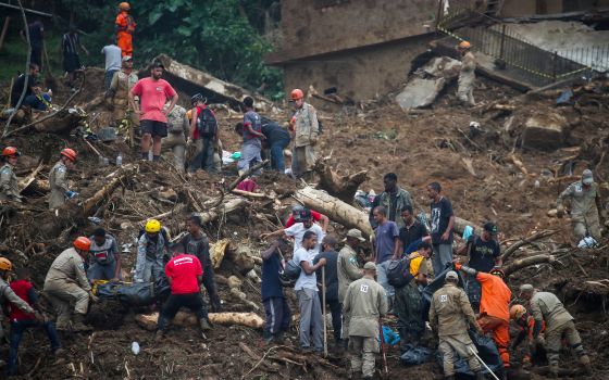 Rescue workers and residents remove a body at the site of a mudslide in Petrópolis, Brazil, Feb. 16, 2022. (CNS photo/Ricardo Moraes, Reuters)