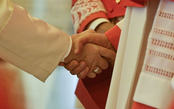 Pope Francis shakes hands with a cardinal during an "ordinary public consistory" for the approval of the canonizations of 10 new saints, at the Vatican March 4, 2022. (CNS photo/Vatican Media)