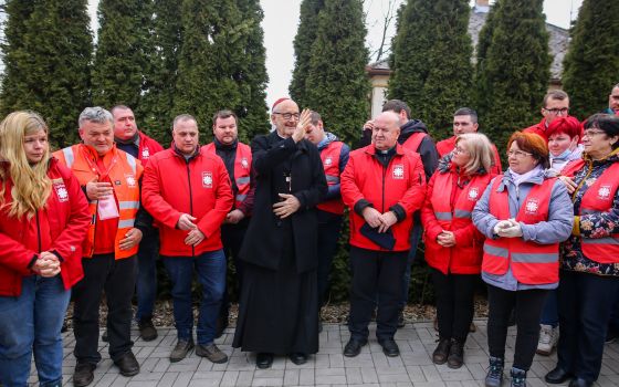 Canadian Cardinal Michael Czerny, interim president of the Dicastery for Promoting Integral Human Development, is pictured with Caritas workers as he gives a blessing during a visit with Ukrainian refugees in Barabás, Hungary, March 9, 2022. (CNS photo/co