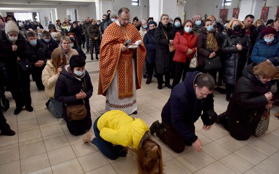 People pray for peace in Ukraine in front of the replica of the original statue of Our Lady of Fatima in the Church of the Nativity of the Blessed Virgin in Lviv, Ukraine, March 18, amid Russia's invasion of the country. (CNS/Reuters/Pavlo Palamarchuk)