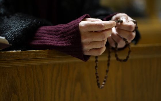 A woman prays the rosary following an evening prayer service at St. George Ukrainian Catholic Church in New York City Jan. 26, 2022. (CNS photo/Gregory A. Shemitz)