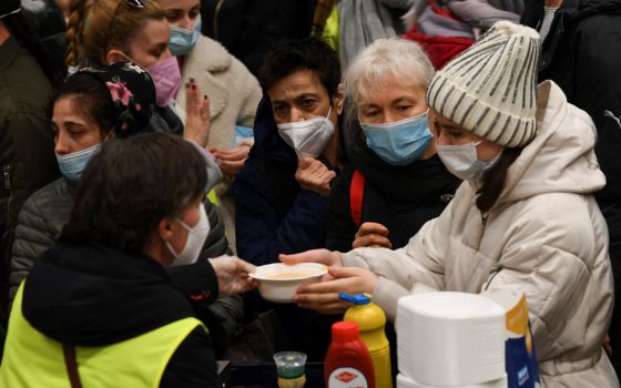 A volunteer hands a bowl of soup to a woman fleeing the Russian war in Ukraine at Berlin's central station March 9, 2022. (CNS photo/Annegret Hilse, Reuters)