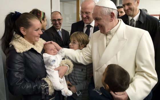Pope Francis blesses a baby during a visit to a Caritas center for the homeless near the Termini rail station in Rome Dec. 18, 2015. (CNS photo/L'Osservatore Romano, handout)