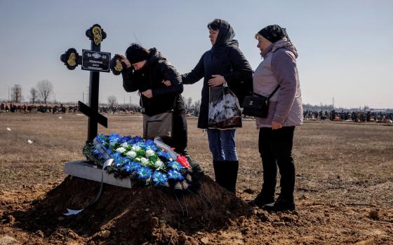 Family members of Borys Romanchenko attend his funeral in Kharkiv, Ukraine, March 24, 2022. Romanchenko, a 96-year-old Holocaust survivor, was killed at his apartment during shelling by Russian forces. (CNS photo/Thomas Peter, Reuters)