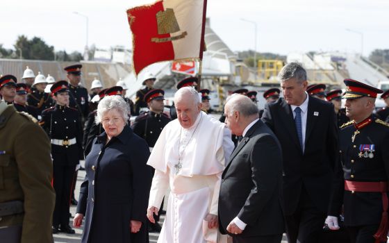 Pope Francis walks with Maltese President George Vella and his wife, Miriam, as he arrives at the international airport in Malta April 2, 2022. The pope was beginning a two-day trip to the Mediterranean archipelago. (CNS/Paul Haring)