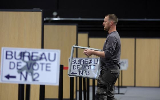 A worker carries a ballot box as he prepares the polling station in Le Touquet-Paris-Plage, France, April 6, for the April 10 presidential election. 