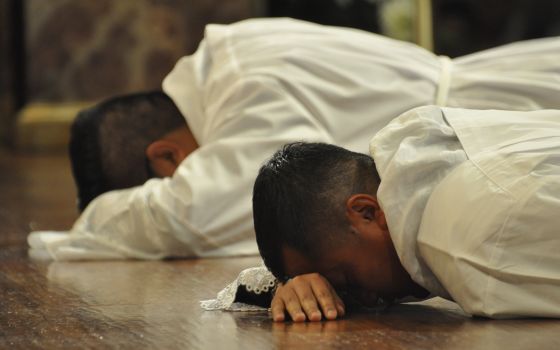 Seminarians Oscar Romero and Augustine Mang prostrate during the Litany of Supplication at their April 9 ordination as transitional deacons at Sagrado Corazon Church in Nashville's Catholic Pastoral Center. (CNS/Tennessee Register/Katie Peterson)